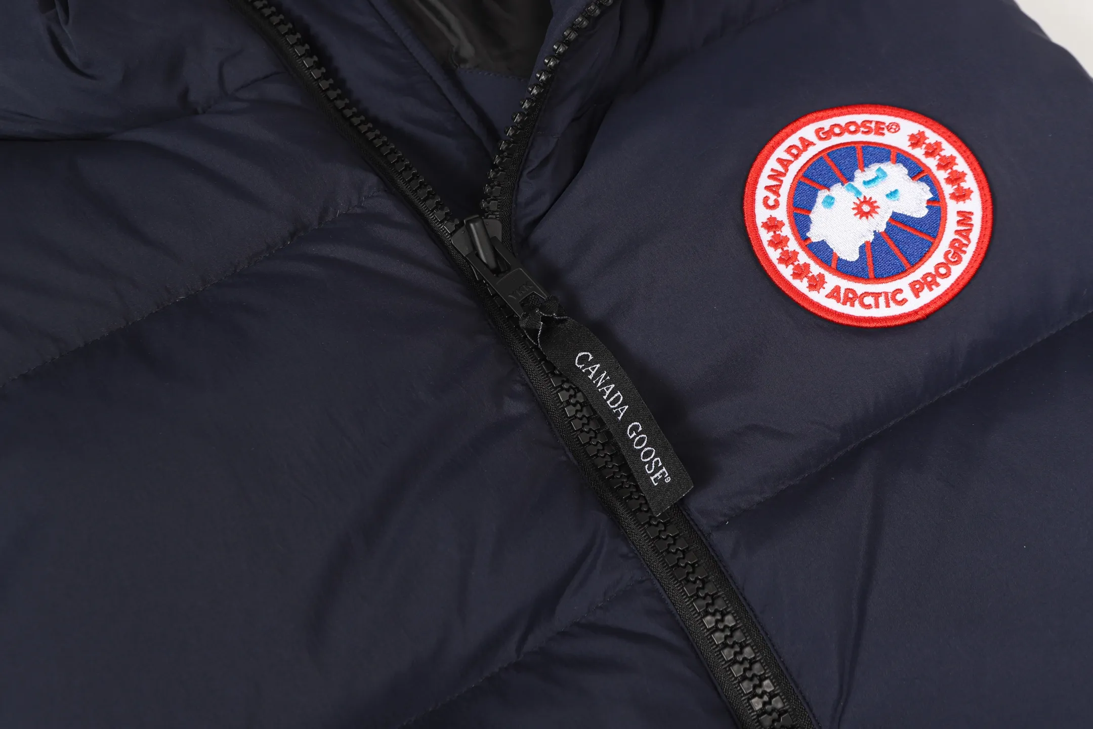 P560 Canada gooes Lawrence down vest (high version) The Lawrence down vest features a durable shell and quilted body, making it a must-have item for all seasons. The fabric has a durable soft touch. Longer hem at back for added protection. Reflective double-stripe grip tape at back. The Lawrence features an engineered down-filled collar to block strong winds, a two-way front zip and a longer rear hem.  Color: black with red label, black with black label, desert color, ocean blue Size: XS-2XL